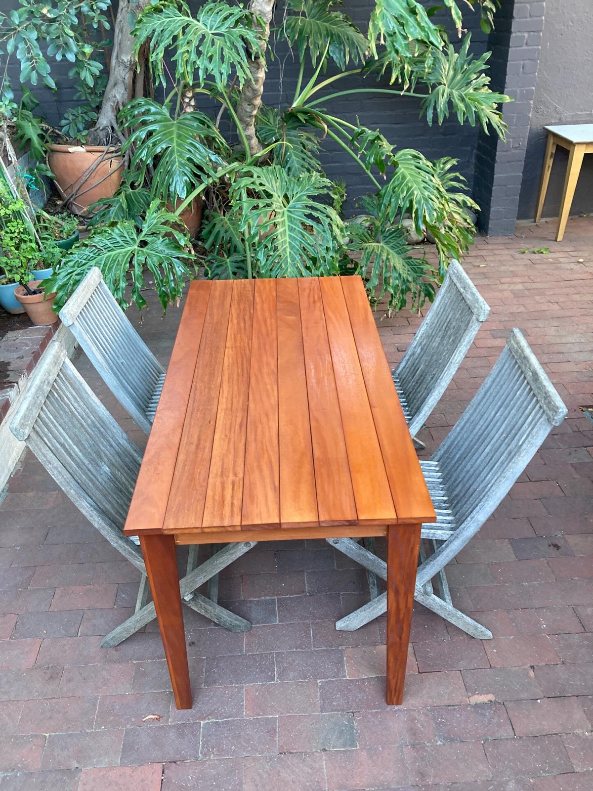 Solid hardwood dining table in a Cape Town courtyard